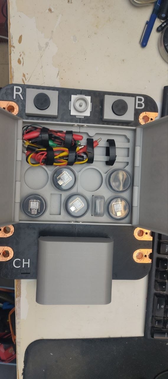 The tray fully loaded: jumper wires and crocodile clip cables secured with velcro, small XIAO-compatible boards and sensor modules in the circular wells.